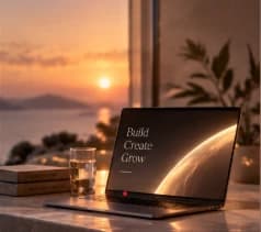 A laptop on a warm stone desk overlooking the sea
